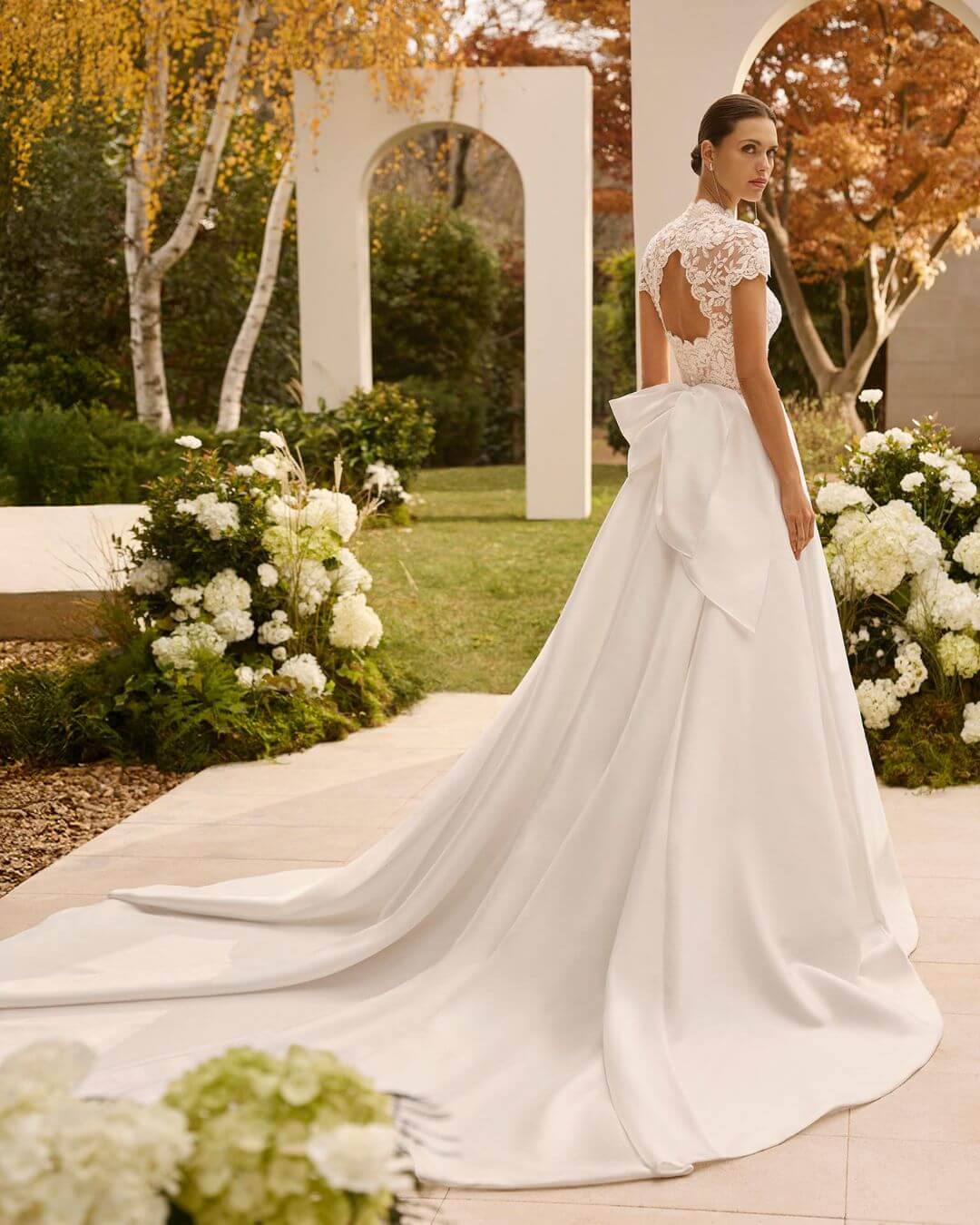 Vista posterior del vestido de novia Nolet con espalda abierta, lazo trasero y amplia cola de apariencia catedral - Modas y Confecciones Beatriz